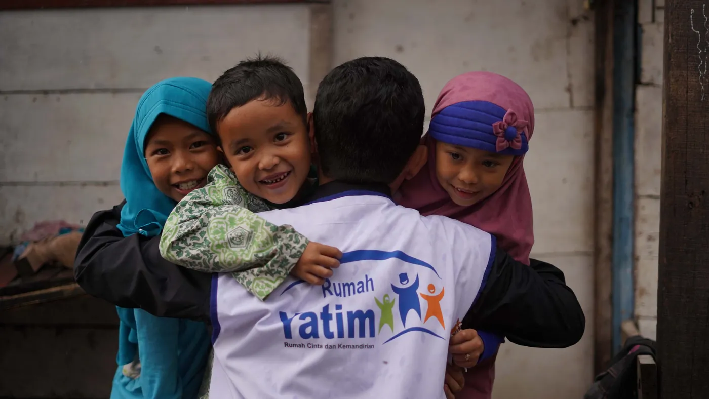 Children hugging a Rumah Yatim volunteer