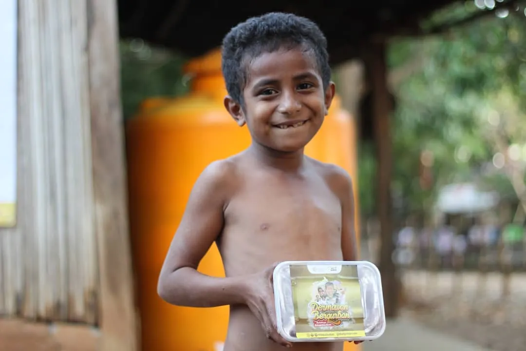Boy smiling with his meal from a feeding program